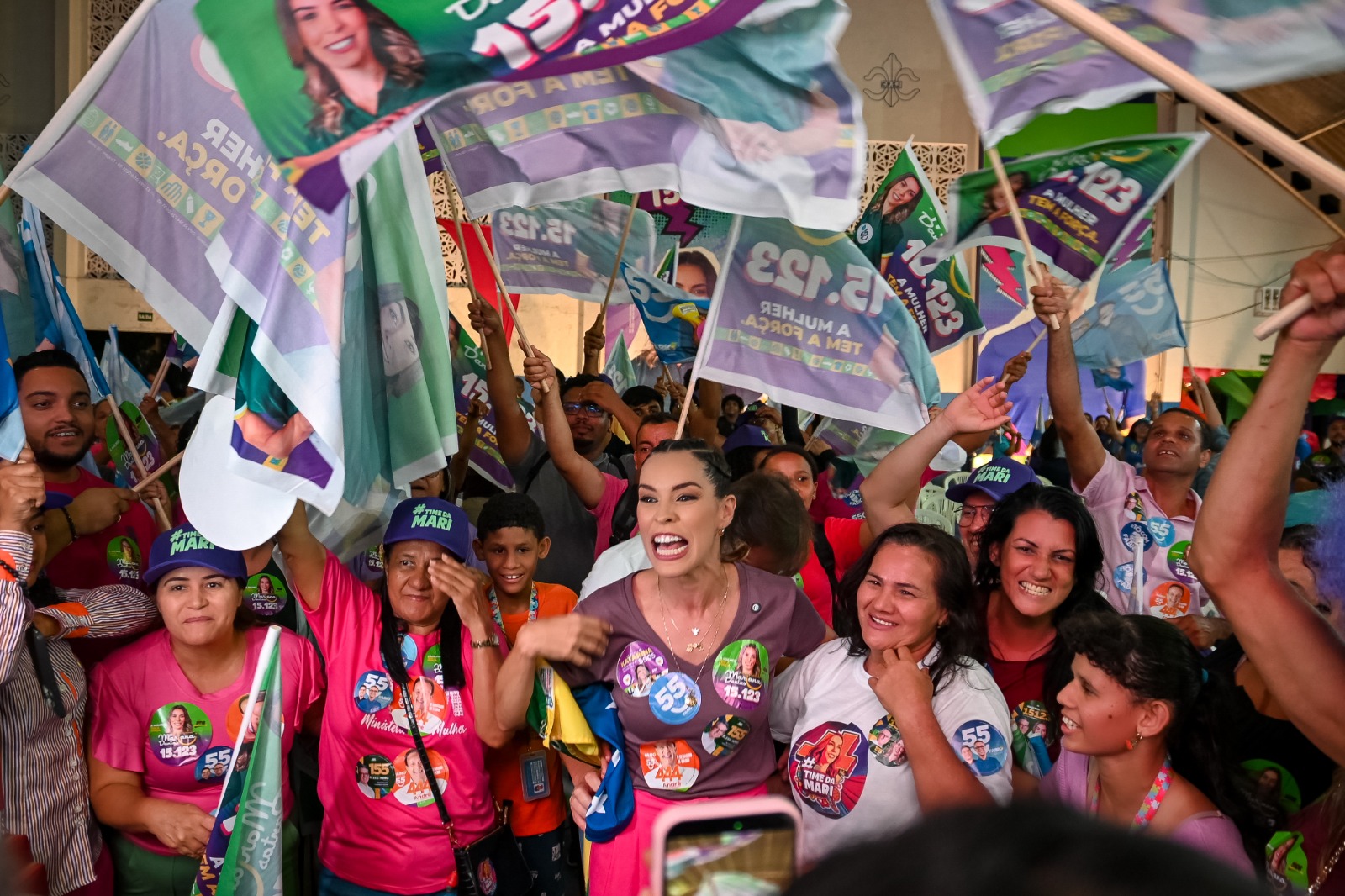 Mariana Dantas no meio dos apoiadores, com bandeiras da campanha 15.123