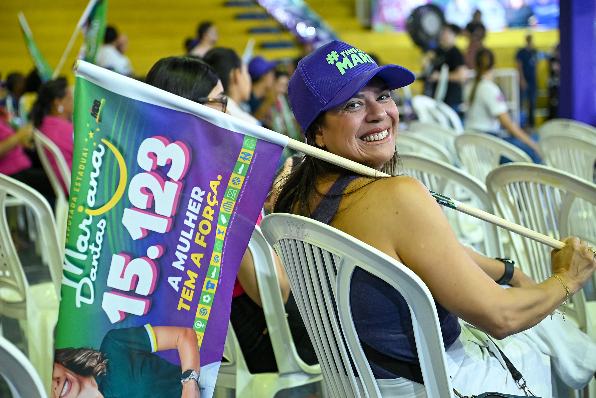 Apoiadora com bandeira da campanha em ginásio