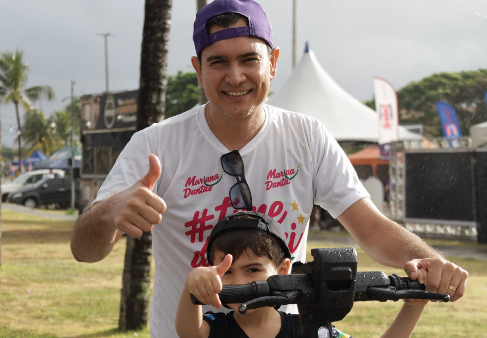 Apoiador do Time da Mari com criança em bicicleta durante o treinão