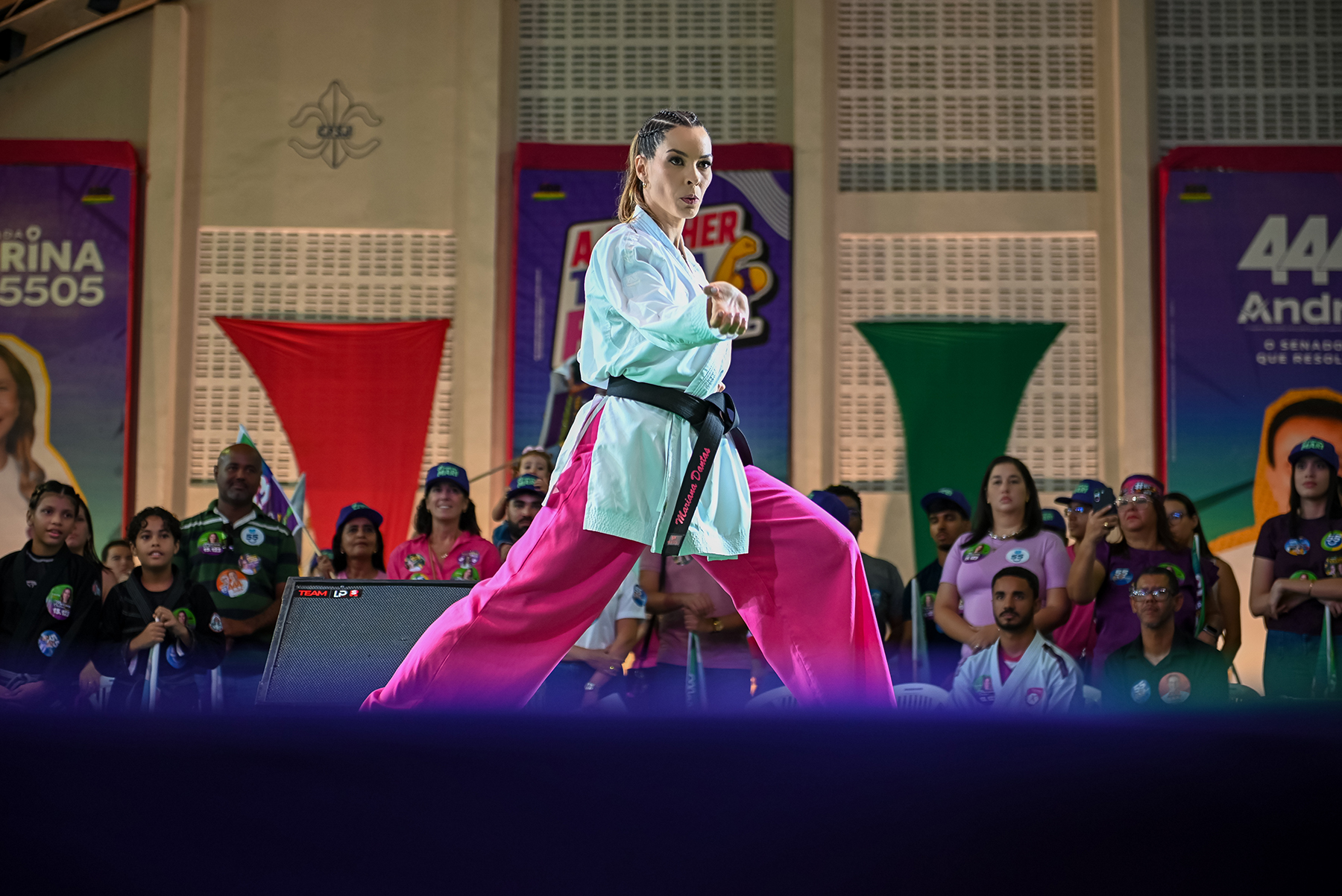 Mariana Dantas apresentando karatê em ginásio, com público acompanhando